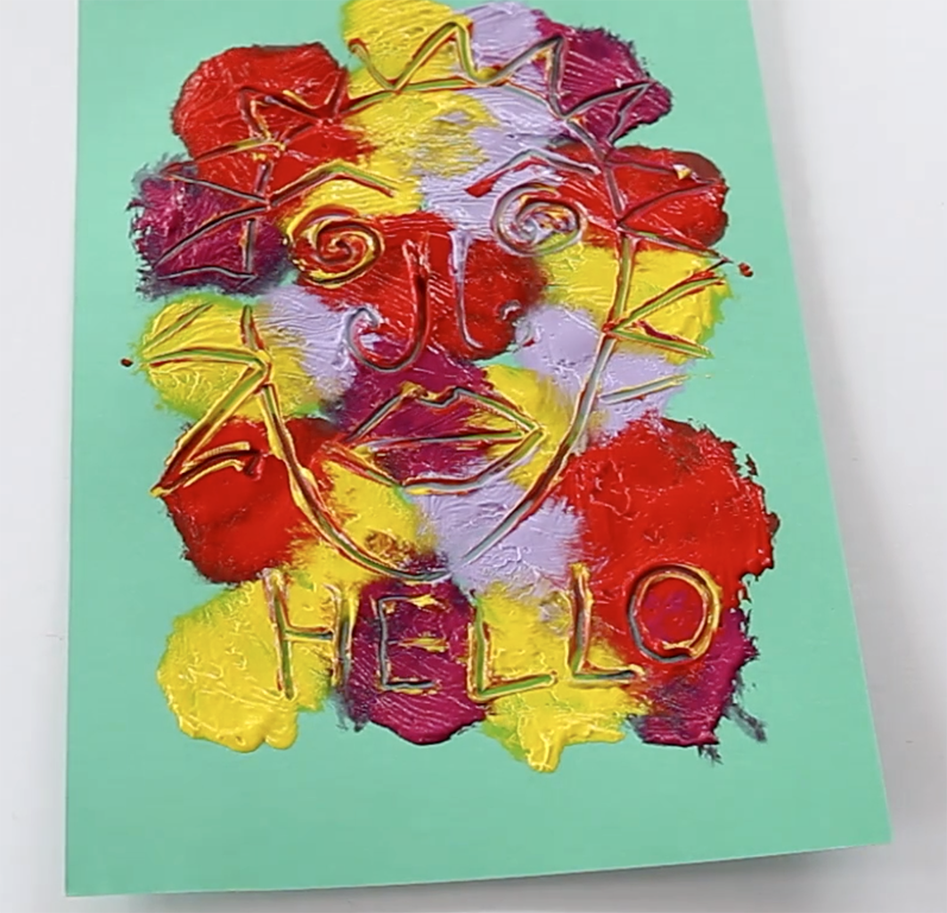 Colourful painted face on green card