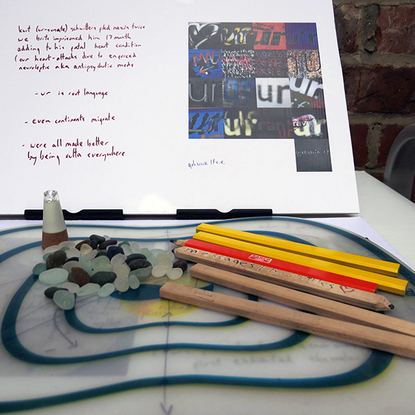 pebbles, pencils on a striped table. in the background is text with images