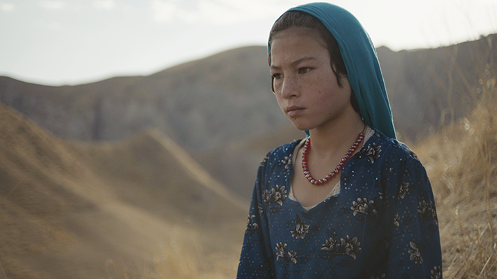 an Asian girl in a blue veil in a beach-like place