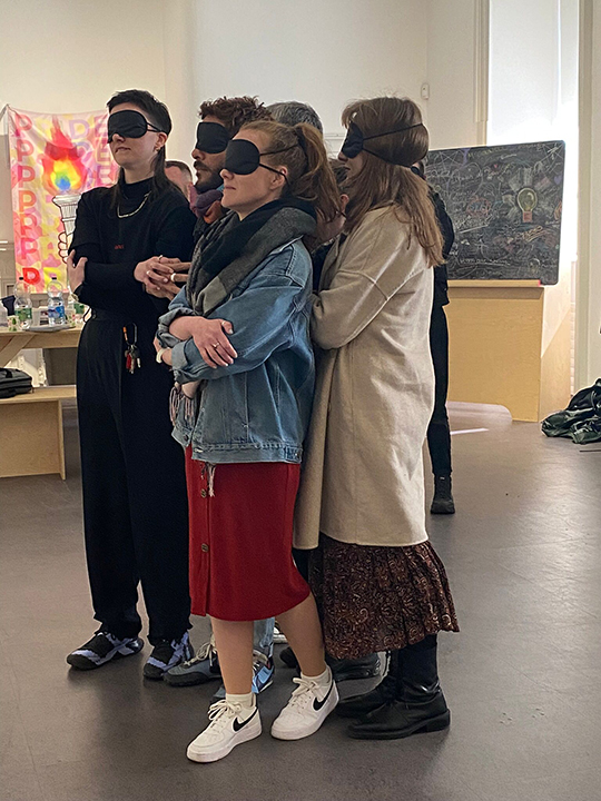8 people blindfolded in the middle of a room