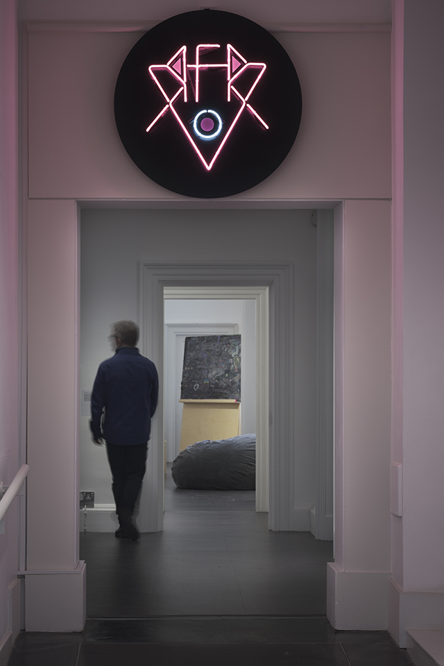 a dark corridor with a moving person and a neon above it