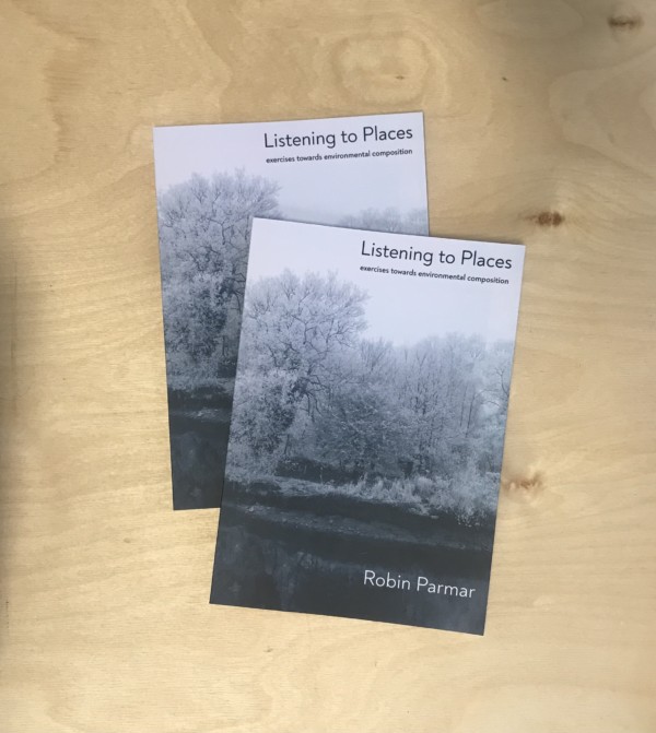 two copies of 'listening to place' by Robin Parmar on a wooden table