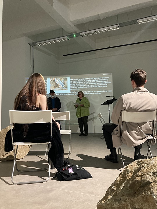 seated people listening to a woman speak