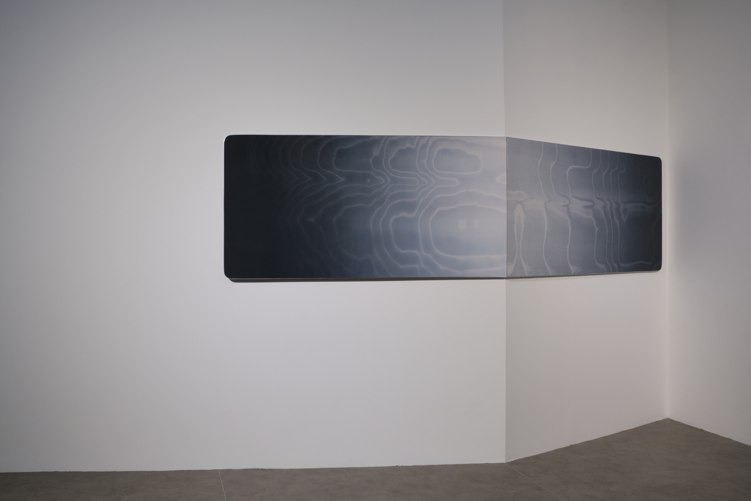 a gray artwork on a white wall