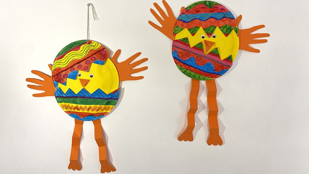 Paper cut out figures in egg shapes, red, yellow and green markings with orange legs and hands