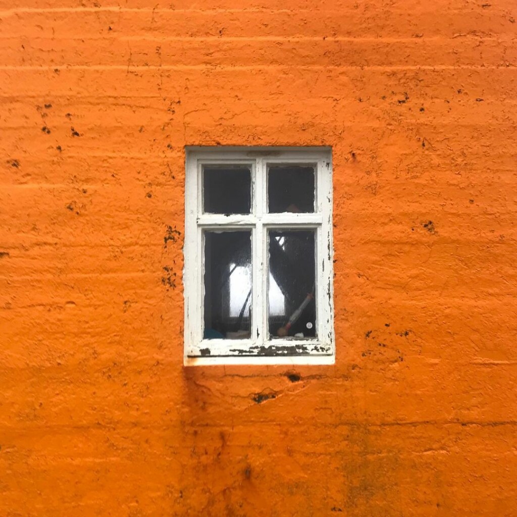 orange wall with a white window in the centre