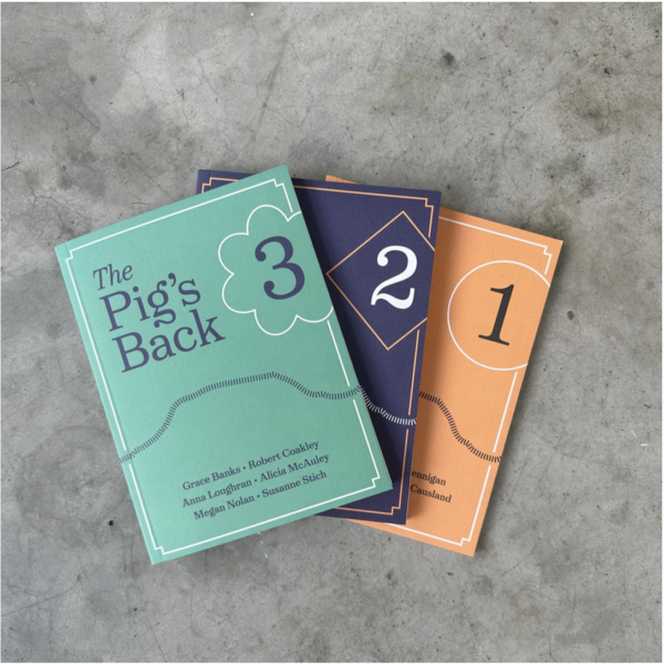 The first three editions of The Pigs Back publication fanned out on a concrete floor.