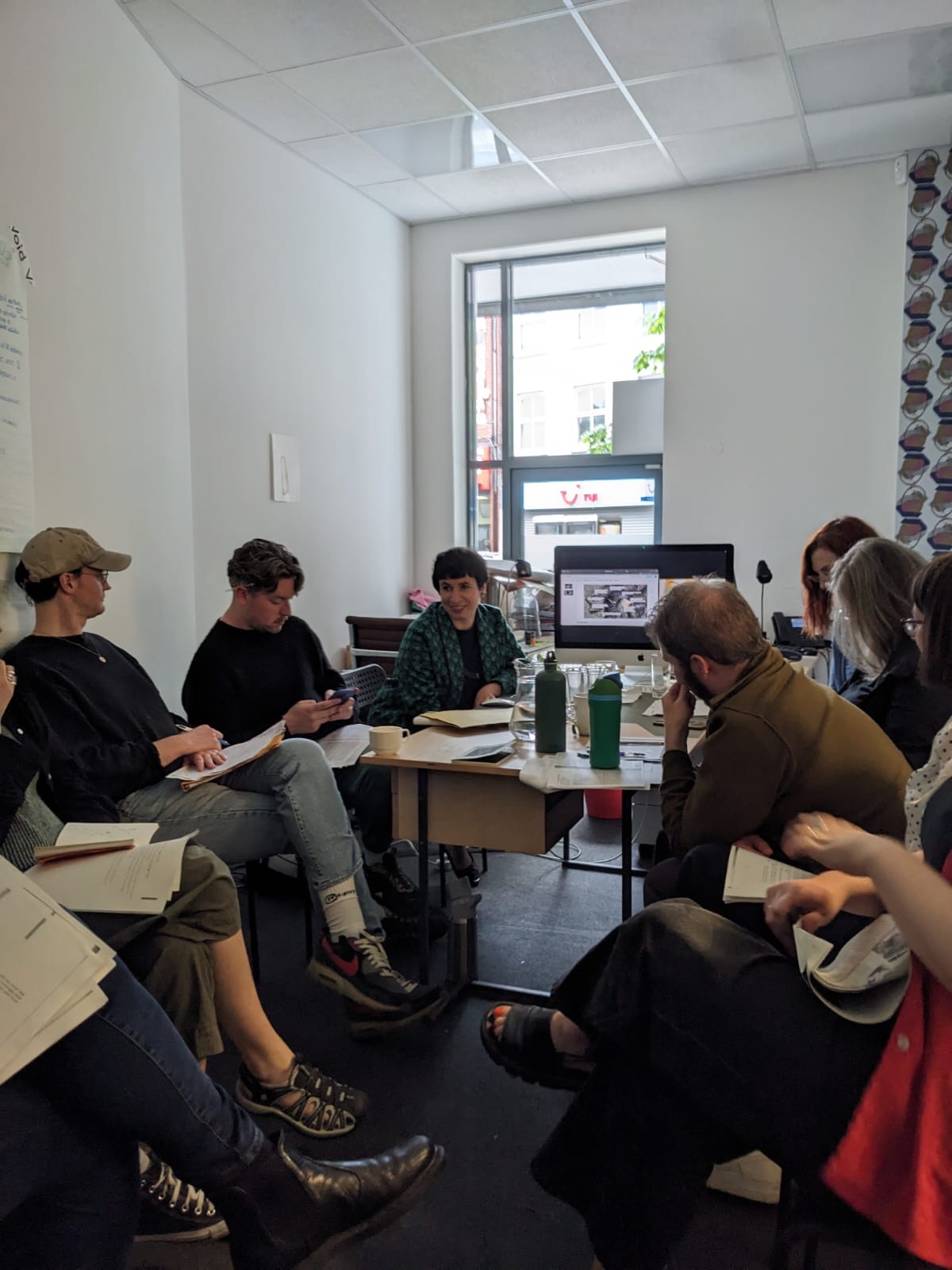 People sitting around a table with readings in their hands